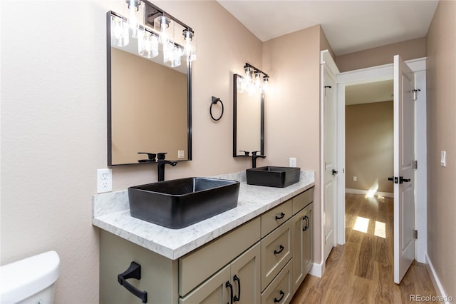 bathroom with vanity, toilet, and hardwood / wood-style floors