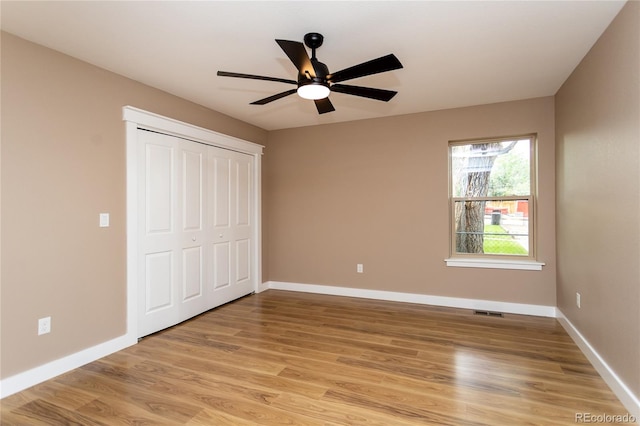 unfurnished bedroom featuring light wood-type flooring, a closet, and ceiling fan