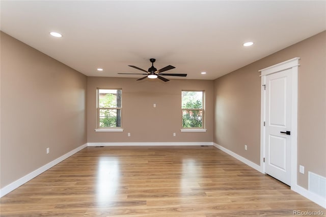 spare room featuring light wood-type flooring, a healthy amount of sunlight, and ceiling fan