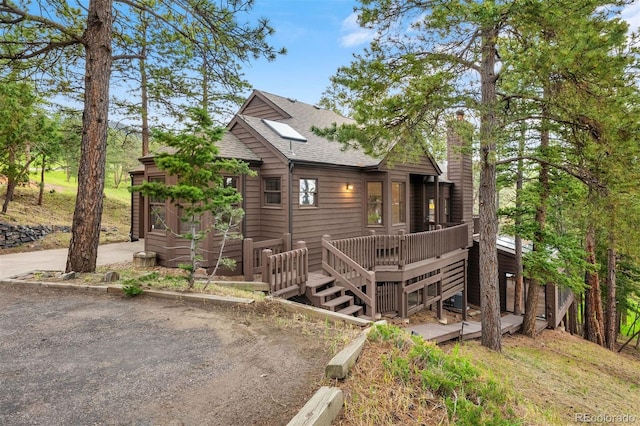 23599 Shingle Creek Rd, Golden, CO 80401 - chalet / cabin with roof with shingles, a wooden deck, and a chimney