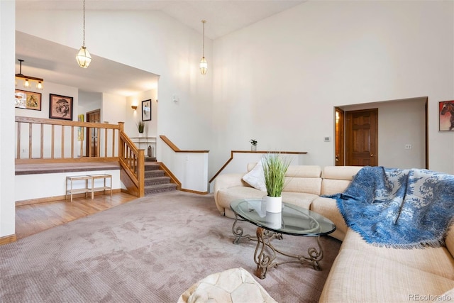 23599 Shingle Creek Rd, Golden, CO 80401 - living area featuring high vaulted ceiling, carpet floors, stairway, and wood finished floors