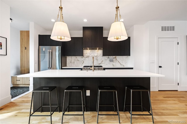 2625 W 23rd Ave, Denver, CO 80211 - kitchen featuring visible vents, high end refrigerator, light countertops, decorative backsplash, and custom exhaust hood