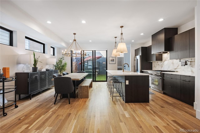 2625 W 23rd Ave, Denver, CO 80211 - kitchen featuring an inviting chandelier, a kitchen bar, premium appliances, light countertops, and light wood-style floors
