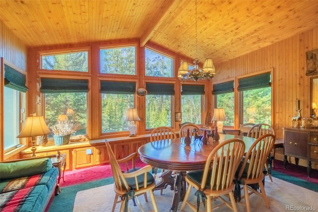 dining room featuring lofted ceiling with beams, wooden ceiling, a chandelier, and carpet