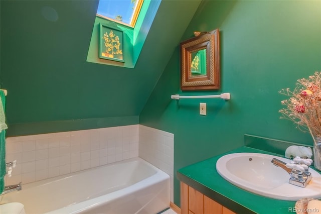 bathroom with a tub to relax in, a skylight, and vanity