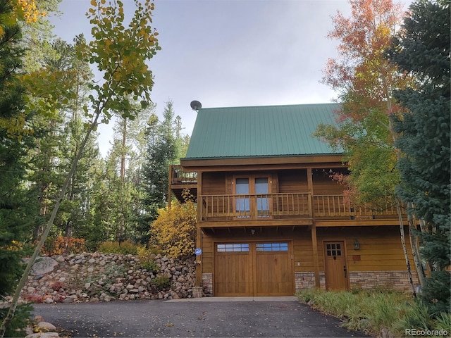 view of front of house featuring a garage and a balcony