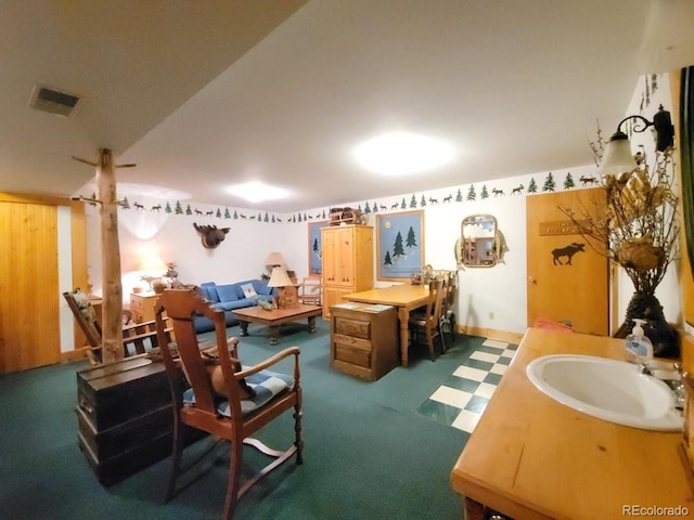 interior space featuring carpet floors, sink, and vaulted ceiling