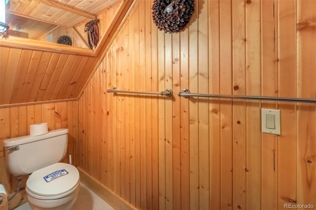 bathroom with toilet, wooden ceiling, wooden walls, and lofted ceiling