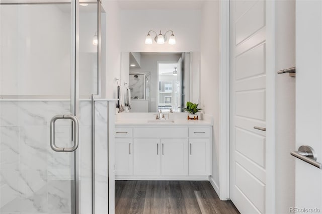 bathroom with wood-type flooring, vanity, ceiling fan, and a shower with shower door