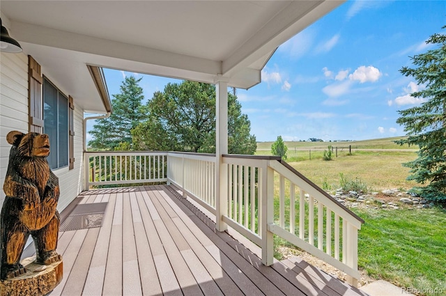 deck with a rural view and a yard