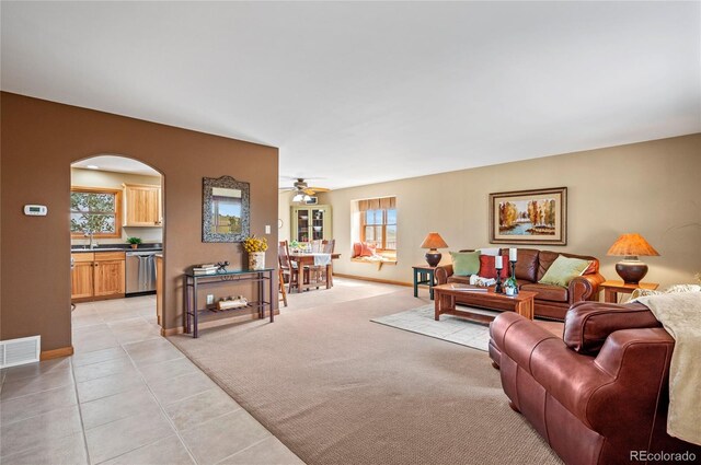 living room with light tile patterned floors, sink, plenty of natural light, and ceiling fan