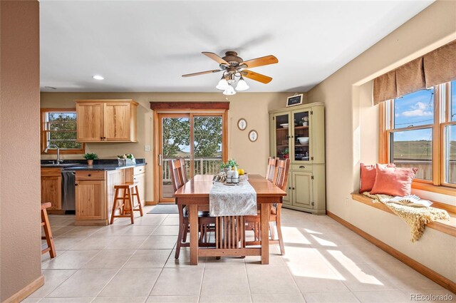 dining room with a wealth of natural light, ceiling fan, light tile patterned flooring, and sink