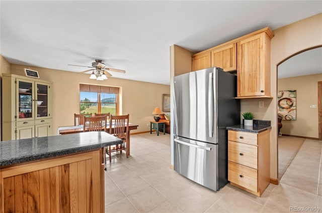 kitchen with ceiling fan, light brown cabinetry, stainless steel fridge, and light tile patterned flooring