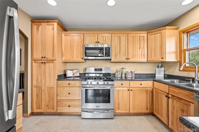 kitchen featuring sink, stainless steel appliances, light tile patterned floors, and light brown cabinets