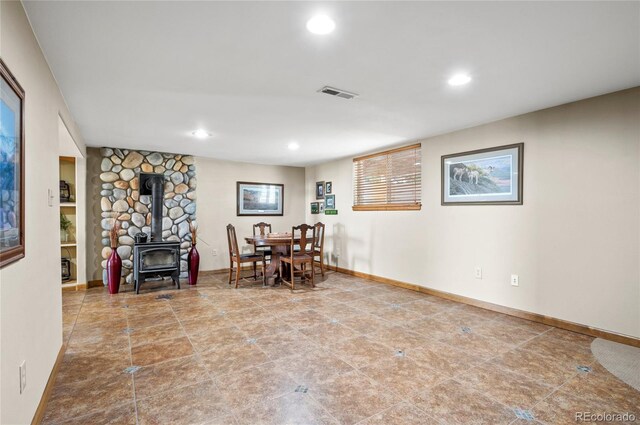 unfurnished dining area with a wood stove and tile patterned flooring