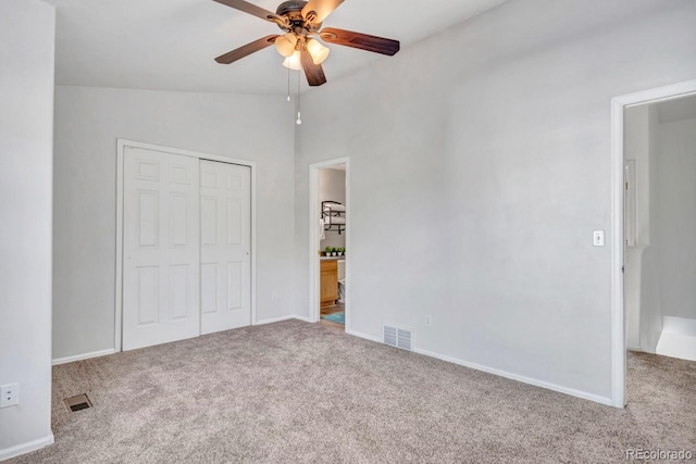 unfurnished bedroom featuring carpet floors, a closet, ceiling fan, and lofted ceiling