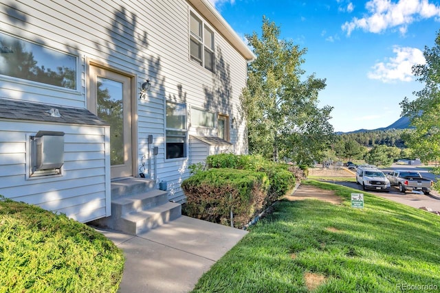 exterior space featuring a mountain view and a lawn