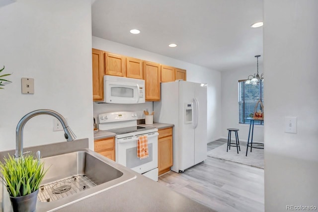 kitchen with sink, hanging light fixtures, white appliances, light brown cabinetry, and light wood-type flooring