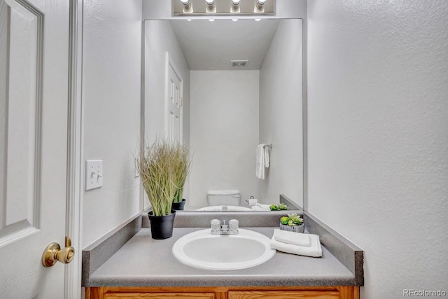 bathroom featuring vanity and toilet