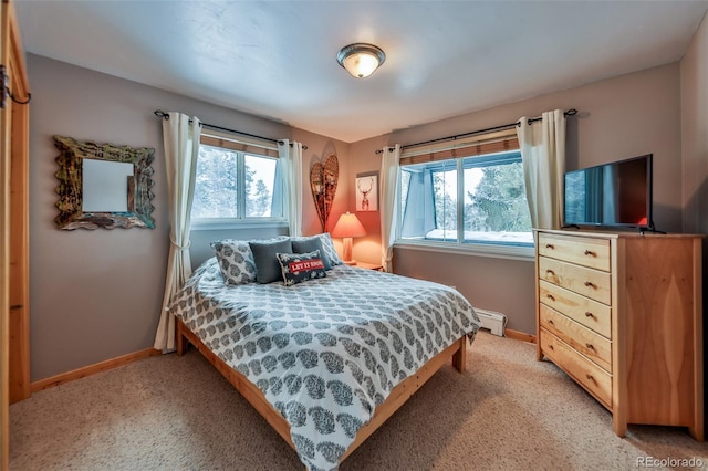 carpeted bedroom featuring baseboard heating and multiple windows