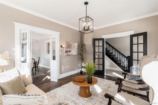 interior space with an inviting chandelier, dark hardwood / wood-style flooring, ornamental molding, and french doors