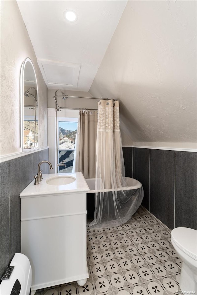 full bathroom with toilet, wood walls, vaulted ceiling, vanity, and shower / bath combination with curtain