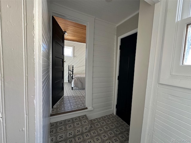 corridor featuring wood walls