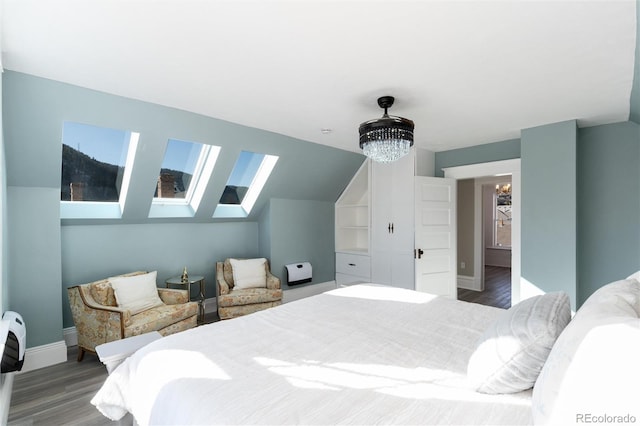 bedroom featuring a notable chandelier, hardwood / wood-style flooring, and vaulted ceiling