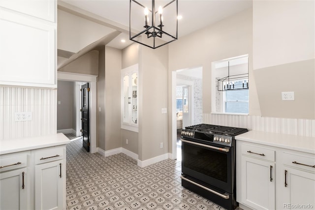 kitchen with pendant lighting, a notable chandelier, range with gas stovetop, and white cabinets