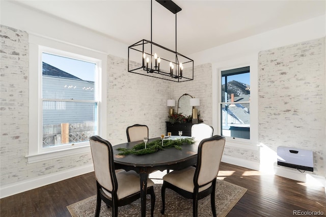 dining space with dark wood-type flooring and a chandelier