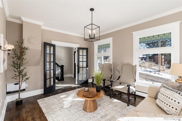 sitting room with dark wood-type flooring, crown molding, an inviting chandelier, and a baseboard heating unit