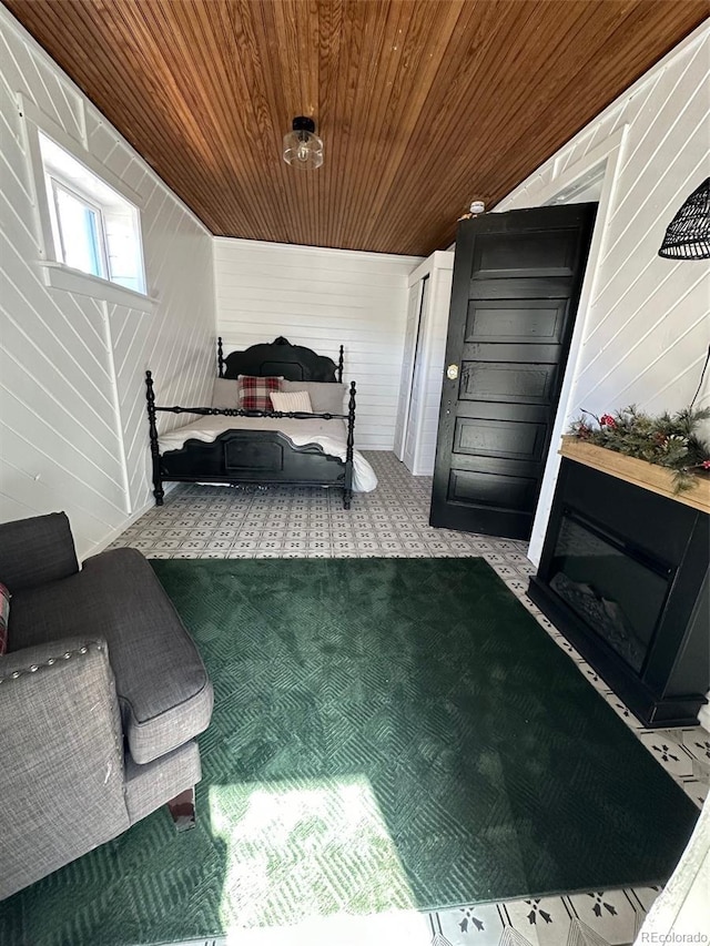 bedroom with wood ceiling and light colored carpet