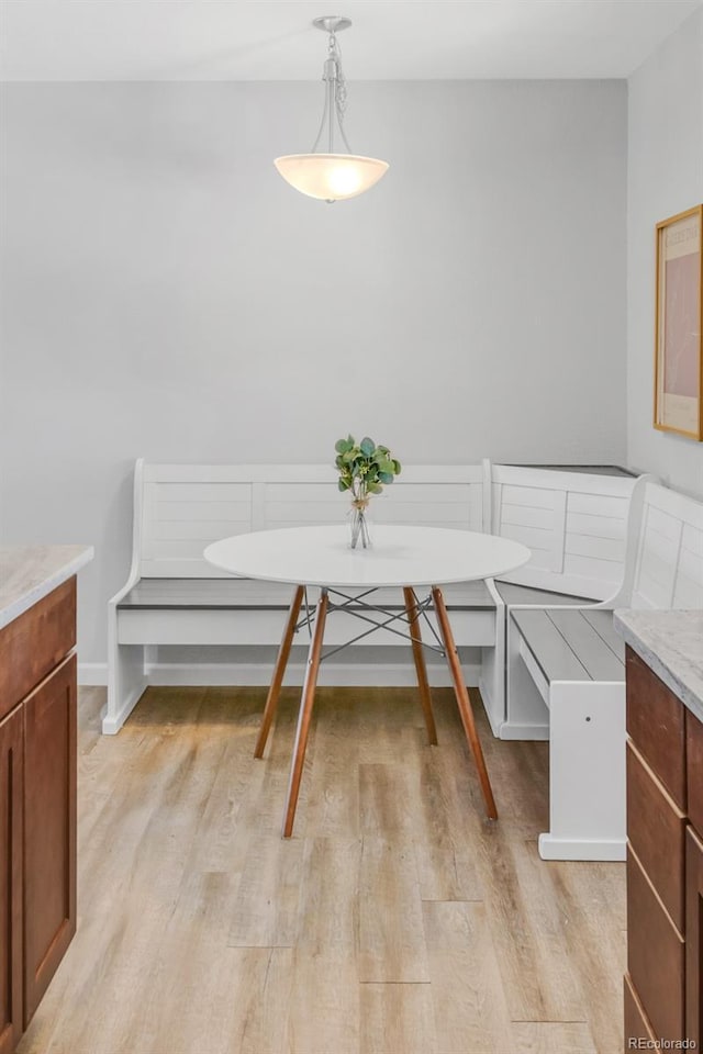 dining space with light wood-type flooring and breakfast area