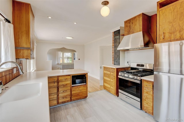 2636 N Glencoe St, Denver, CO 80207 - kitchen featuring stainless steel appliances, wall chimney range hood, a sink, crown molding, and light countertops