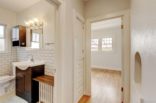 2636 N Glencoe St, Denver, CO 80207 - bathroom with vanity, toilet, wood finished floors, and a chandelier