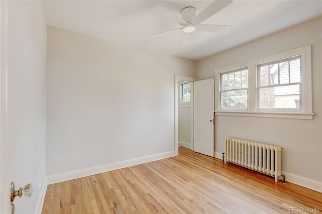 2636 N Glencoe St, Denver, CO 80207 - spare room with radiator heating unit, healthy amount of natural light, wood finished floors, and baseboards