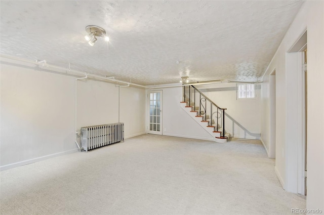 2636 N Glencoe St, Denver, CO 80207 - basement with radiator heating unit, a textured ceiling, carpet flooring, stairs, and baseboards