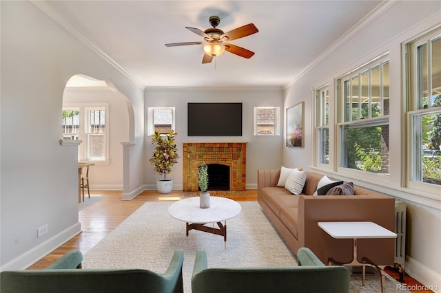 2636 N Glencoe St, Denver, CO 80207 - living room with crown molding, ceiling fan, wood finished floors, a brick fireplace, and baseboards