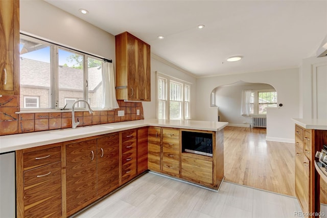 2636 N Glencoe St, Denver, CO 80207 - kitchen featuring black microwave, a sink, arched walkways, radiator heating unit, and brown cabinets