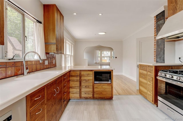2636 N Glencoe St, Denver, CO 80207 - kitchen featuring wall chimney exhaust hood, a sink, stainless steel range with gas stovetop, black microwave, and crown molding
