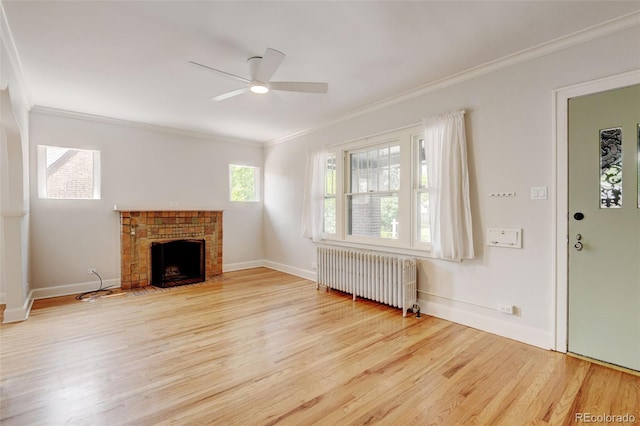2636 N Glencoe St, Denver, CO 80207 - unfurnished living room featuring radiator heating unit, crown molding, wood finished floors, a ceiling fan, and a fireplace