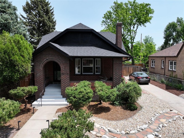 2636 N Glencoe St, Denver, CO 80207 - view of front of house with brick siding, roof with shingles, a porch, and a chimney