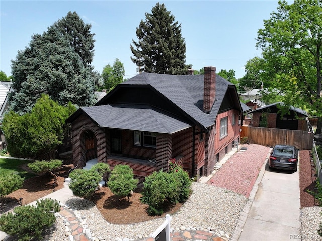 2636 N Glencoe St, Denver, CO 80207 - view of front facade featuring roof with shingles, brick siding, covered porch, a chimney, and driveway