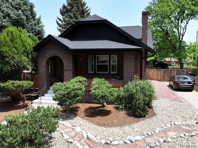 2636 N Glencoe St, Denver, CO 80207 - view of front of house featuring brick siding, a chimney, and roof with shingles