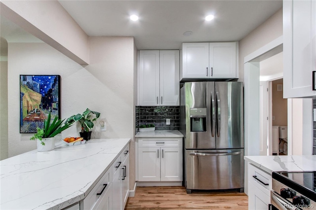 1969 Uinta St, Denver, CO 80220 - kitchen with appliances with stainless steel finishes, light stone counters, light wood-style floors, white cabinetry, and recessed lighting