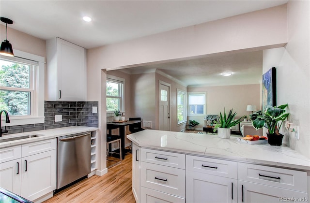 1969 Uinta St, Denver, CO 80220 - kitchen featuring stainless steel dishwasher, a peninsula, light wood-type flooring, white cabinets, and decorative backsplash
