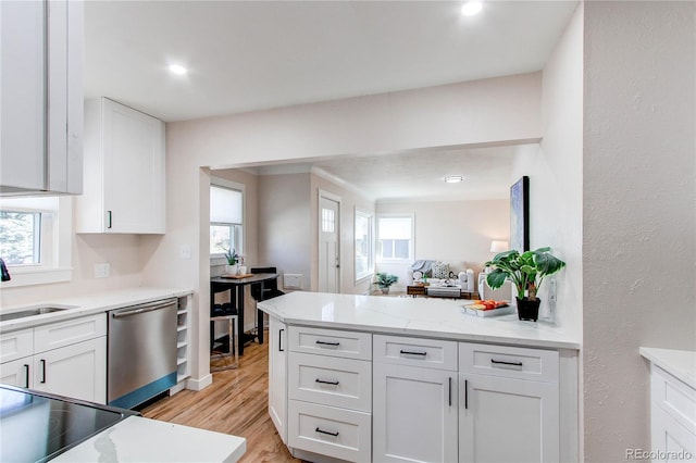 1969 Uinta St, Denver, CO 80220 - kitchen with stainless steel dishwasher, white cabinetry, light wood finished floors, a peninsula, and light stone counters
