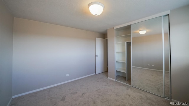 unfurnished bedroom featuring light colored carpet and a closet