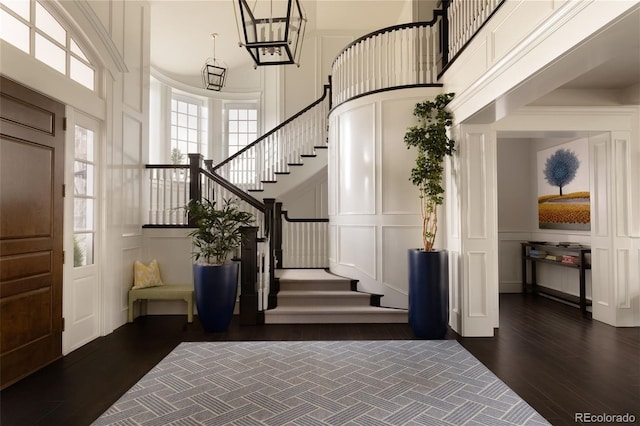 5470 S Highline Cir, Greenwood Village, CO 80121 - entrance foyer with a decorative wall, a towering ceiling, stairway, dark wood-style flooring, and a chandelier