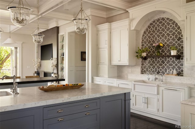 5470 S Highline Cir, Greenwood Village, CO 80121 - kitchen featuring a chandelier, light stone countertops, pendant lighting, a sink, and beam ceiling